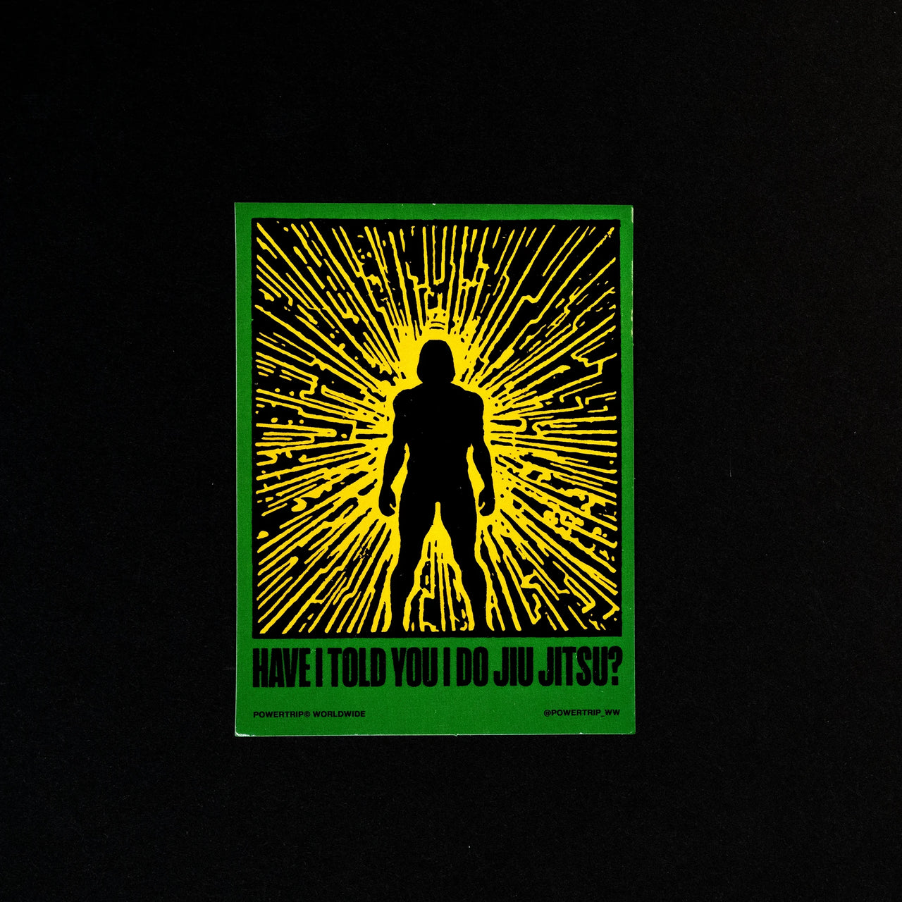 Rectangular sticker. Shows image of a black silhouette against a yellow lit background with a green border. The text reads "Have I told you I do Jiu Jitsu?"